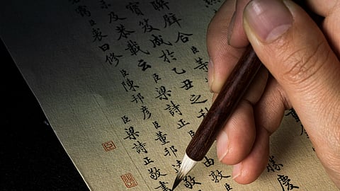 chinese letters written on brown paper with ink pen