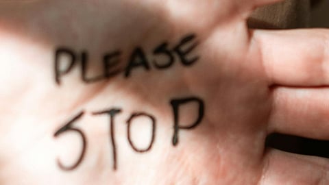 a hand, palm side up written please stop