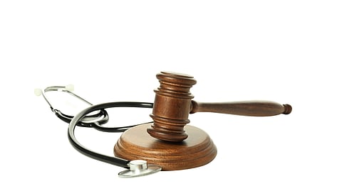 Image of a stethoscope and gravel justice in front of a white background.