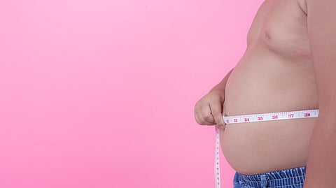Image of an obese child measuring with an inch tape.
