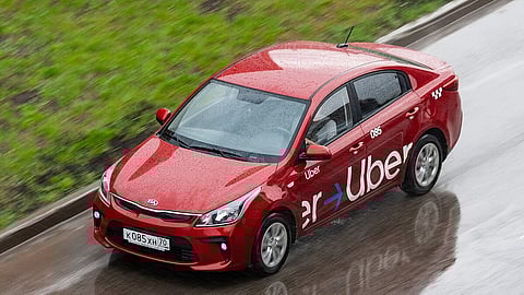 A red uber car on a road. 