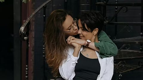 An image of 2 girls on a staircase, holding eachother.