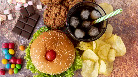 Image showing different junk foods on a table like coke, burger, chips, etc.