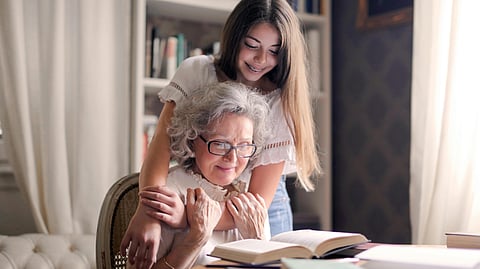 Smiling elderly woman talking with caregiver about mental health support in a safe care setting.