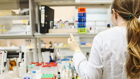 An image of a girl working in a lab surrounded with samples.