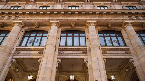 Image of a huge historical building having big pillars and windows.