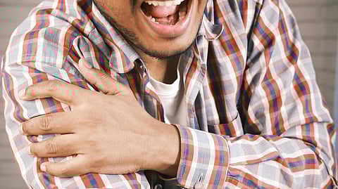 An image of a man experiencing pain in his arm.