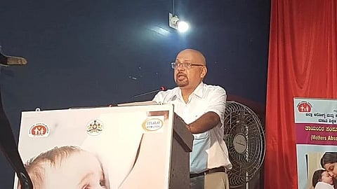 Image of Dr. P.V. Bhandary wearing a white shirt and spectacles giving the speech in an event.