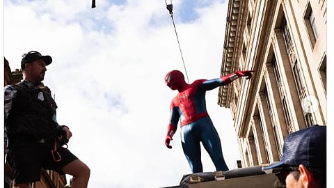 An image of Tom Holland on the shooting set in the spiderman costume.