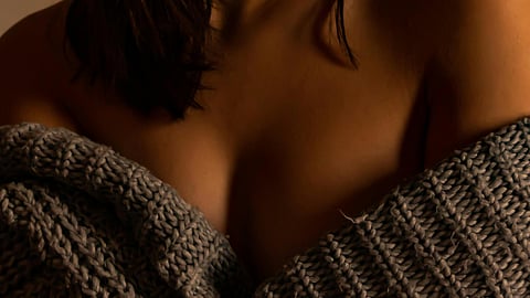 Image of a woman wearing a sweater of greyish color.