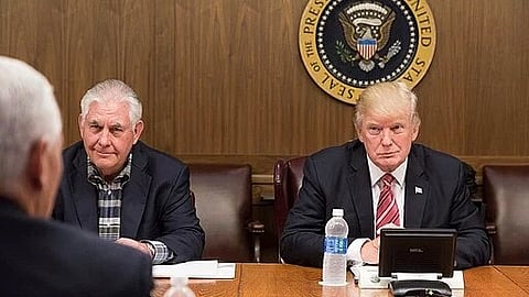 Image of 2 men sitting beside each other wearing formal clothes.