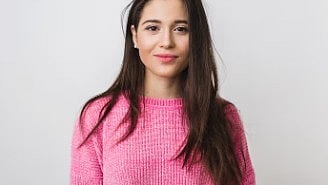Blurred image of a woman in pink sweater.