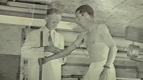 A doctor measuring the arm width of a participant in the experiment.