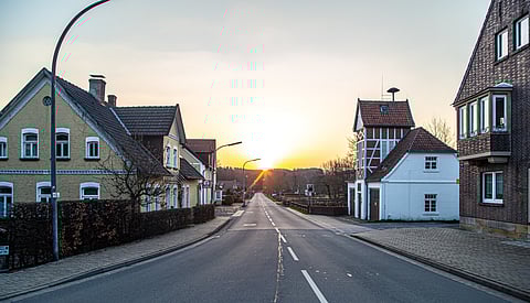 Image of a quiet street with houses at sunset.