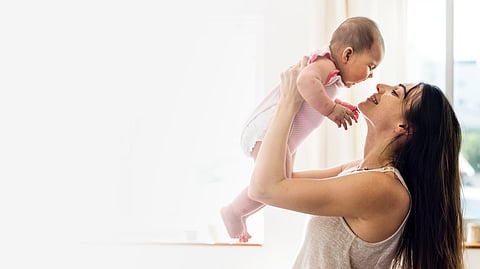 Image of a woman playing with her kids.
