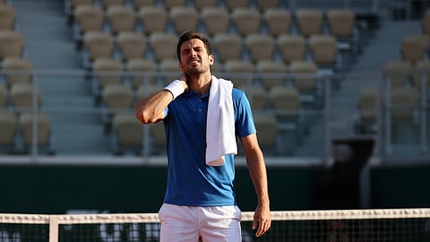 Image of a man suffering from neck pain during his tennis match.