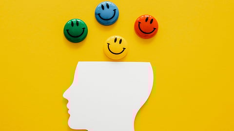 Image of illustrations of smiley emojis in front of a yellow background.