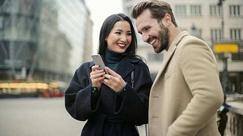 Image of a couple looking at a phone.