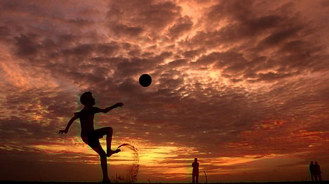 Image of a kid playing with a ball in a dreamy evening.