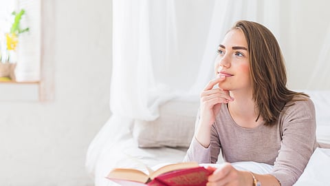 Image of a woman wearing grey t-shirt and thinking.