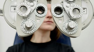 An image of a person sitting with eye medical equipment.