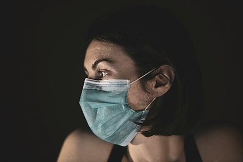 A woman wearing a surgical mask, emphasizing health and safety in a public setting.