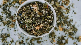 Image of herbs present in a bowl and also scattered over the floor.