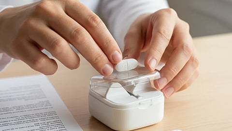 Image of a person splitting a tablet by using a tablet splitter.