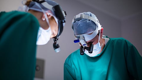Surgeons wearing surgical loupes while performing operation.