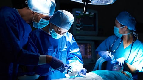 A team of surgeons operating in a theatre.