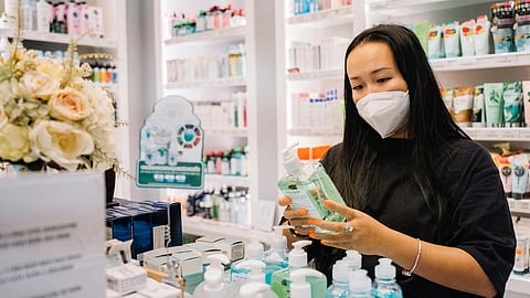 Image of a person reading label of a product in the drugstore.