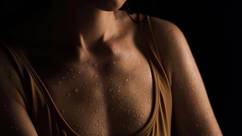 Image of a woman sweating immensely and wearing yellow tank top.