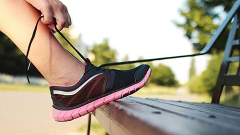 An image of someone tying their shoe lace.
