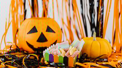 Image of a pumpkin along with Halloween candies.