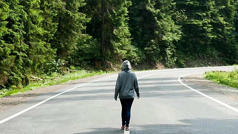 An image of a person walking on road.