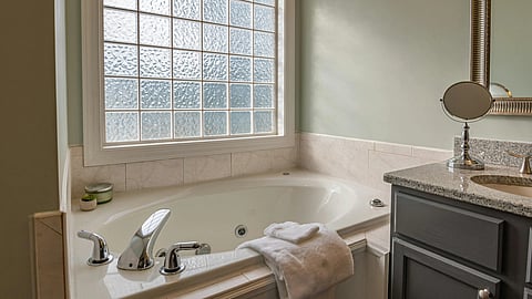Image of an aesthetic bathroom having bathtub, towels, sink, etc.