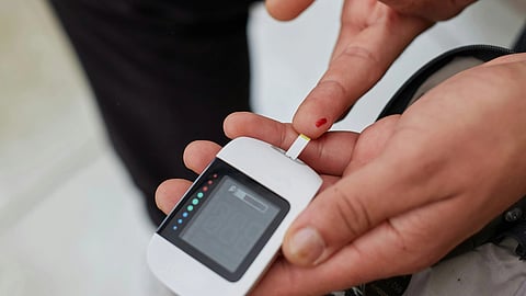 A person holds a small electronic device in their hand.