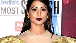 Image of Hina Khan wearing a golden dress in an award show.