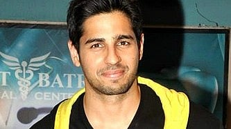 Image of Sidharth Malhotra for his picture's premiere in a black and yellow jacket.