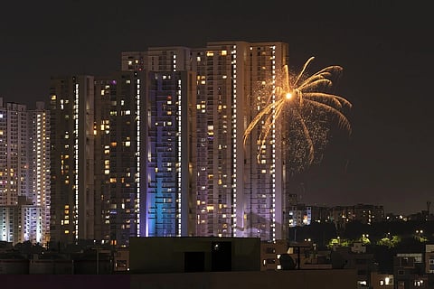 A firework exploding in the backdrop of a high rise building. 