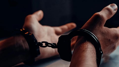 An image of a person's handcuffed hands.