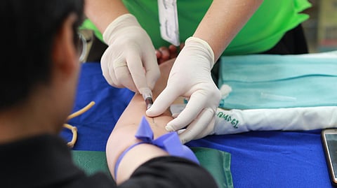 Image of a medical college teacher treating a patient.