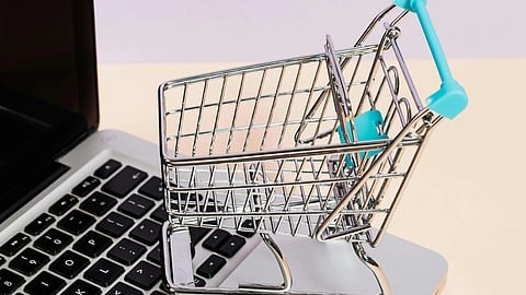 Graphical image of a shopping cart over a laptop depicting AI and Online Shopping.