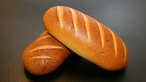 Image of two loaves of bread lying one over the other in front of blue background.
