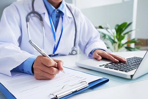 An image of a doctor in a clinic with a laptop.