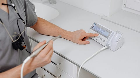 Image of an orthodontist using an advanced tool for a treatment.