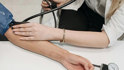 An image of someone taking another person's blood pressure.