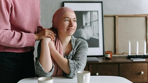 Image of a woman in a headscarf sitting at a table with a man in a depressing mood.