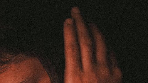 Close-up image of a woman's hand on her hair signifying fear.