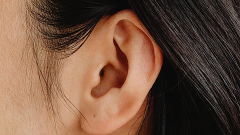 A woman with long black hair gazes upward, her expression thoughtful and contemplative.